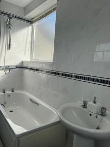 a white bathroom with a tub and a sink at Alexander Apartments West Harton in South Shields