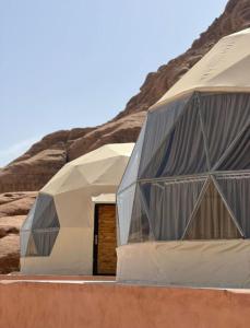 two domes in the middle of a desert at Mishari Wadi Rum camp in Disah