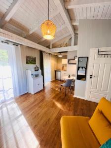 a living room with a yellow couch and a kitchen at Pension und Appartements alter Fehrbelliner Bahnhof in Fehrbellin