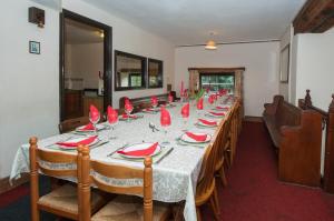 een lange tafel met rode borden en servetten erop bij Makeney Chapel in Duffield