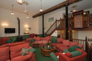 a living room with red couches and a tv at Makeney Chapel in Duffield