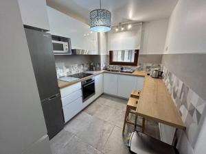 a kitchen with white cabinets and a table in it at Splendid 92m2 Renovated, 4 Rooms in Charenton-le-Pont