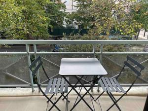 ein Tisch und zwei Stühle auf einem Balkon in der Unterkunft Splendid 92m2 Renovated, 4 Rooms in Charenton-le-Pont
