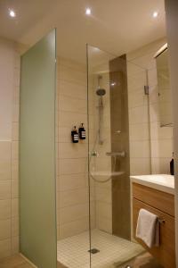 La salle de bains est pourvue d'une douche avec une porte en verre. dans l'établissement Stilvolle Wohnung mit Balkon & Parkplatz, à Rostock