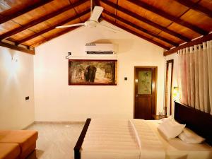 1 dormitorio con 1 cama y ventilador de techo en Wilpattu Blue Sapphire lite - B&B, en Wilpattu