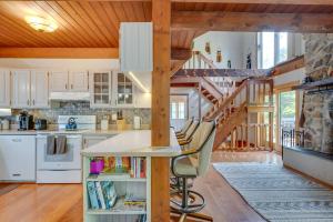 a kitchen with white cabinets and a wooden staircase at Mountain-View Jackson Hideaway with Deck! in Jackson
