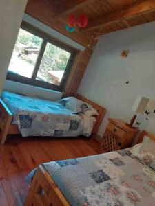 a bedroom with two beds and a window at Preciosa casa, vistas y piscina privada in Pucón
