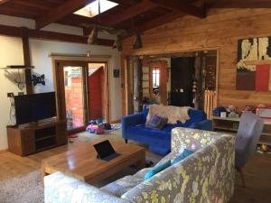 sala de estar con sofá azul y mesa en Preciosa casa, vistas y piscina privada, en Pucón