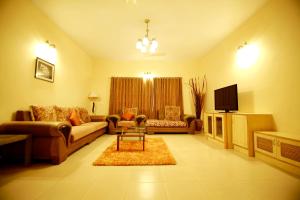 a living room with a couch and a tv at Falcon Suites Residency Road in Bangalore