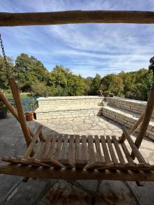 une balançoire en bois assise au-dessus d'un mur de briques dans l'établissement Arktouros Hotel, à Monodendri