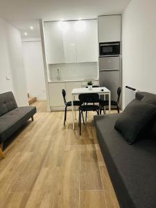 sala de estar con sofá, mesa y cocina en BERNABEU/ C.UNIVERSITARIA APARTMENTS en Madrid
