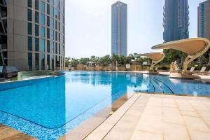 ein großes Schwimmbad in einer Stadt mit hohen Gebäuden in der Unterkunft Burj Vista, Downtown Dubai - Burj Khalifa View - Mint Stay in Dubai