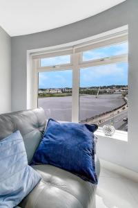 ein Ledersofa in einem Zimmer mit einem großen Fenster in der Unterkunft The Peace Bridge Apartment in Derry Londonderry