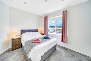 un dormitorio con una cama y una ventana en The Peace Bridge Apartment, en Derry Londonderry
