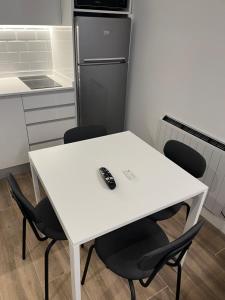 a white table with four chairs and a refrigerator at BERNABEU/ C.UNIVERSITARIA APARTMENTS in Madrid