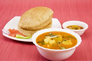 um prato de comida com uma tigela de sopa e uma sanduíche em HOTEL JKM PALACE Near Apollo Hospital em Nova Deli