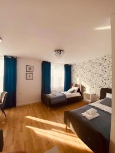 a bedroom with two beds and blue curtains at Metalowiec in Stalowa Wola