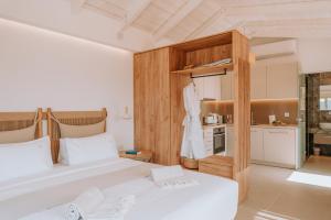 a bedroom with two beds and a kitchen at Sivota's Secret Villa in Sivota