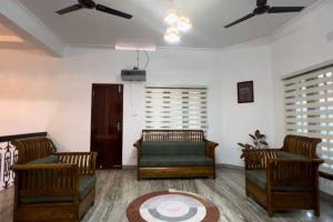 a living room with two chairs and a couch at Hosted by Resmi Jayalal in Cochin
