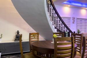 a dining room with a wooden table and chairs at Hosted by Resmi Jayalal in Cochin
