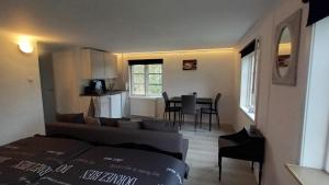 een woonkamer en een keuken met een bank en een tafel bij Allemanshem in Lenhovda