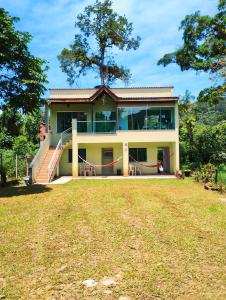 una casa con un gran patio delante de ella en Pacífico Sul Suítes, en Ubatuba