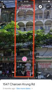 ein Schild vor einem Gebäude mit orangefarbenen Stangen in der Unterkunft Room Bangkok in Godown