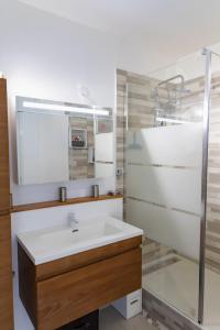 ein Bad mit einem Waschbecken und einem Spiegel in der Unterkunft Résidence La Canonnière in Le Diamant
