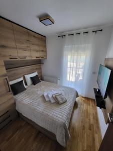 um quarto com uma cama grande com duas almofadas em Apartman Adam Divčibare em Divčibare