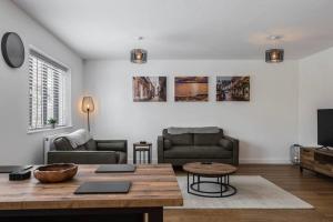 a living room with a couch and a table at The Montague: Newly built two bedroom apartment with parking in Kent