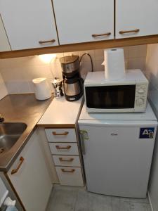 een keuken met een magnetron en een koelkast bij Pet-friendly 4 Bed Apt in Turku with Park views in Turku
