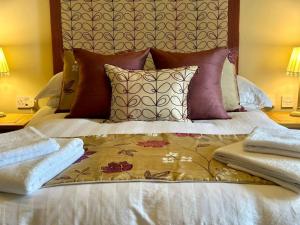 un letto con cuscini e asciugamani sopra di Booth House a Elslack