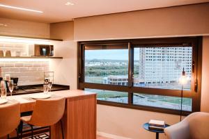 a kitchen with a large window with a view of a city at Loft com vista para o Parque Una in Pelotas