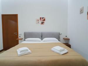 um quarto com uma cama com duas toalhas em Da Sara em Pozzuoli