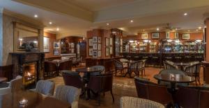 a restaurant with tables and chairs and a fireplace at Granville Hotel in Waterford