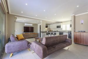 ein Wohnzimmer mit 2 Sofas und einer Küche in der Unterkunft Villa Moderno B in Oludeniz
