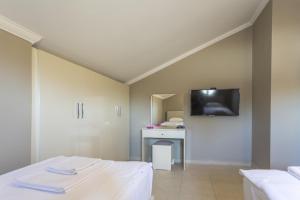 a room with two beds and a tv on the wall at Villa Moderno B in Oludeniz