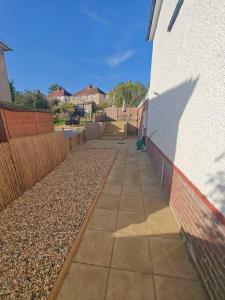 a sidewalk next to a building with a fence at Stunning 4 bed House Ideal for Contractors in Southampton