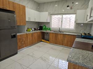 uma cozinha vazia com armários de madeira e uma janela em KAMS Clubhouse Lifecamp, 24 power em Abuja