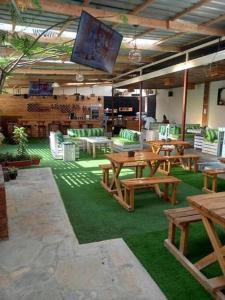 een restaurant met houten tafels en stoelen en een flatscreen-tv bij The Crib House-Kitengela in Kitengela 