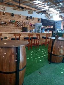 a bar with wooden stools and tables in a restaurant at The Crib House-Kitengela in Kitengela 