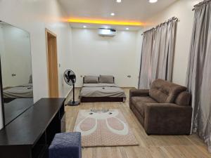 uma sala de estar com um sofá e uma mesa em KAMS Clubhouse Lifecamp, 24 power em Abuja