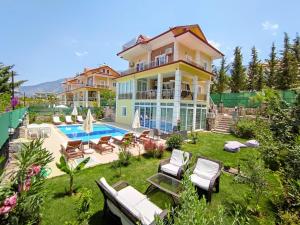 a large house with a swimming pool in the yard at Alpine Villa at Hisarönü Ölüdeniz Ovacık Fethiye 6+2, 12 People in Fethiye