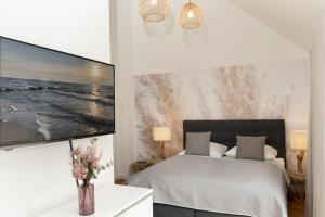 ein Schlafzimmer mit einem Bett und einem TV an der Wand in der Unterkunft Meerlust in Scharbeutz