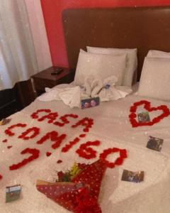 a bed with red flowers on it with a bedspread at Hotel Casa Alpina in Núcleo Mauá