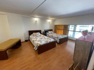 pokój hotelowy z 2 łóżkami i stołem w obiekcie Duplex In Siwar, 3 Br, Wifi, Parking, Near Rimal w mieście Makhāḑat Nahr al Kalb
