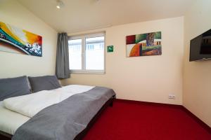 a bedroom with a bed and paintings on the wall at Reinoldus Hotel Dortmund in Dortmund