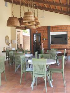 a restaurant with tables and chairs and a brick wall at POUSADA DOS LAGOS in Paulino Neves