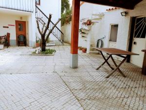 een patio met een houten tafel en een bank bij Casa dos Quatro Irmãos in Gouveia