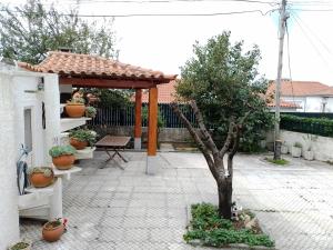 een paviljoen met een tafel en een boom op een binnenplaats bij Casa dos Quatro Irmãos in Gouveia